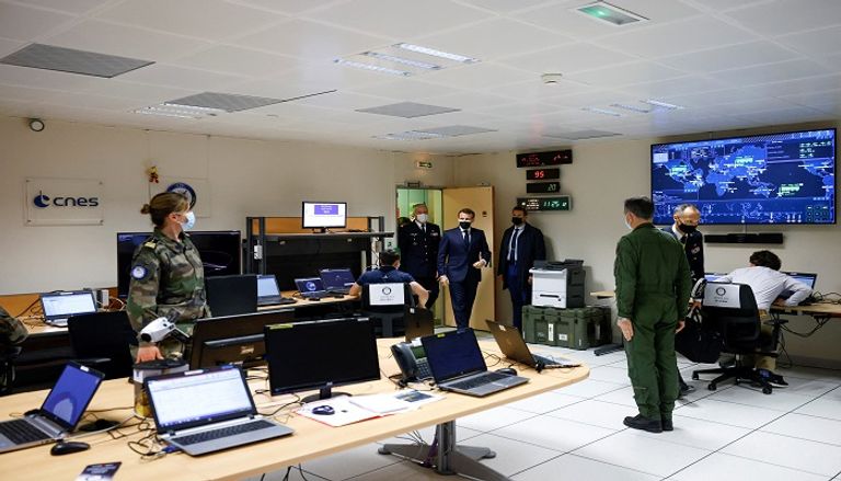 ماكرون خلال مشاركته في أول مناروات عسكرية بالفضاء- أ.ف.ب