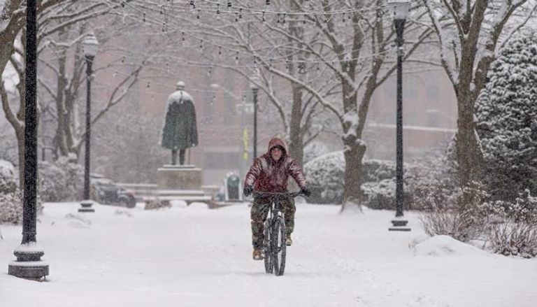 رجل يستقل دراجة وسط الثلوج