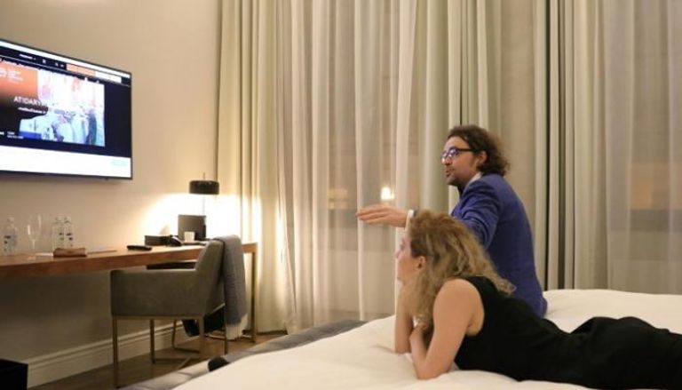 مشاركان في مهرجان فيلنيوس السينمائي يشاهدان أحد أفلام الحدث من غرفة الفندق