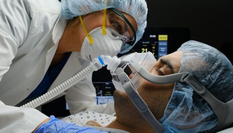 طبيب يتابع مريضا على جهاز التنفس الصناعي