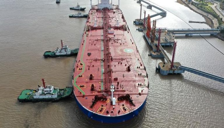 عمال الميناء يفرغون النفط الخام من ناقلة نفط في مدينة تشوشان بالصين- رويترز