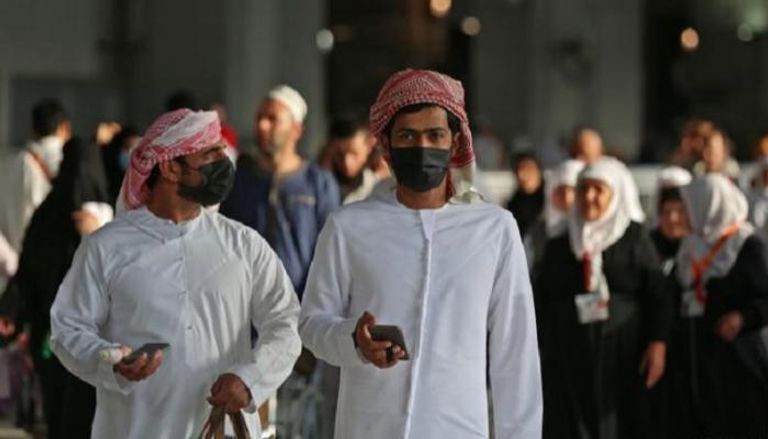 رجلان يرتديان كمامتين للوقاية من فيروس كورونا في السعودية (أرشيفية)