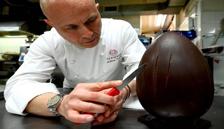 صاحب المتجر مع منحوتات من بيض الشوكولاتة