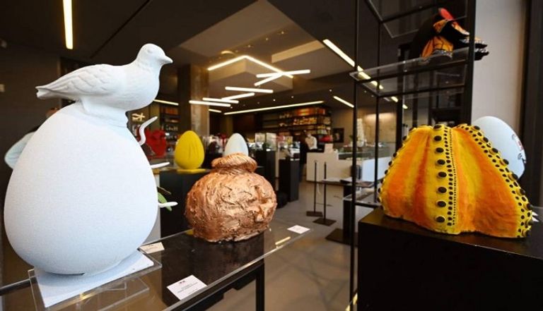 صاحب المتجر مع منحوتات من بيض الشوكولاتة