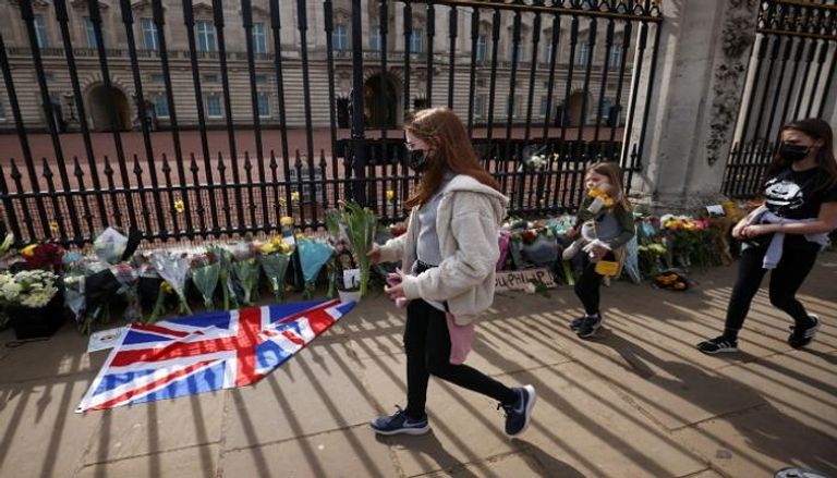 بريطانيون يضعون الزهور على أسوار قصر باكينجهام- رويترز