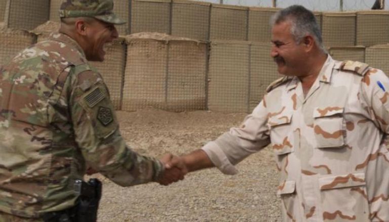 ضابط عراقي يصافح مسؤولا عسكريا بالتحالف الدولي