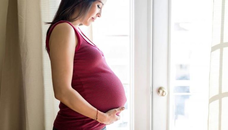 سيدة حامل تنظر بسعادة إلى الجنين في بطنها