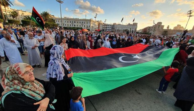 ليبيون يحملون علم بلادهم في أحد ميادين طرابلس - أرشيفية