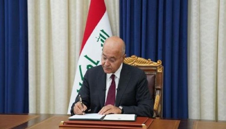 الرئيس العراقي خلال التوقيع على مرسوم إجراء الانتخابات 