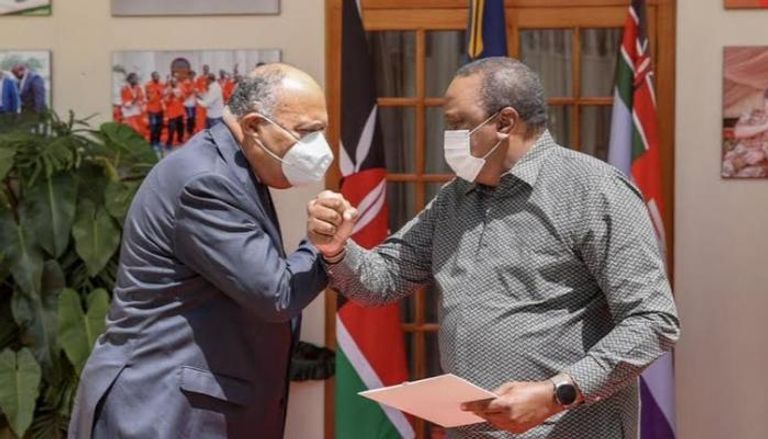 الرئيس الكيني يصافح وزير الخارجية المصري