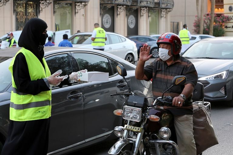 متطوع بالحملة يقدم وجبة إفطار إلى أحد قائدي السيارات