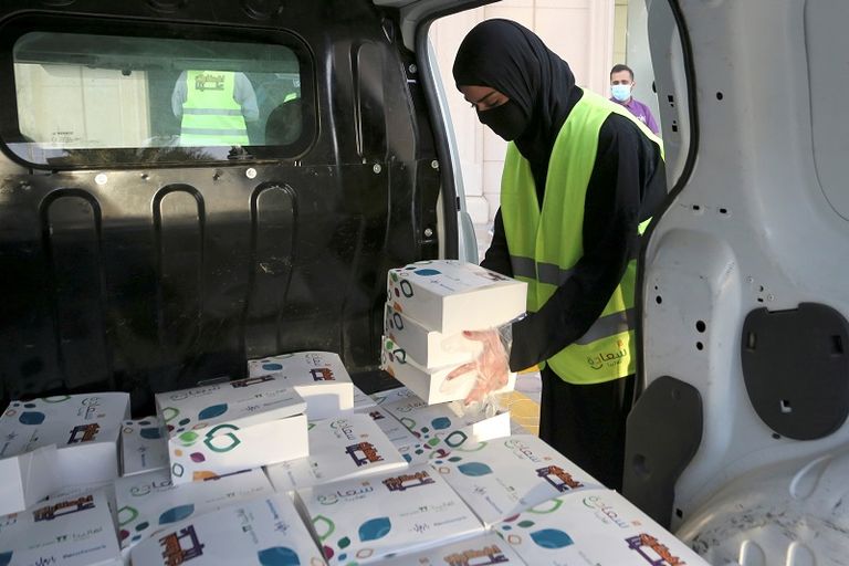 متطوع بالحملة يقدم وجبة إفطار إلى أحد قائدي السيارات