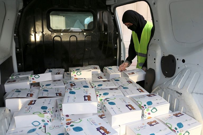 متطوع بالحملة يقدم وجبة إفطار إلى أحد قائدي السيارات