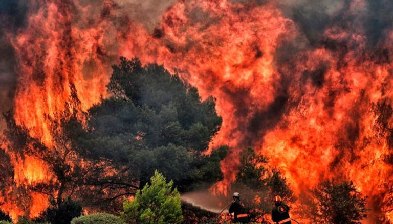 رجال الإطفاء يحاولون وأد ألسنة اللهب المشتعلة بغابات قريبة من العاصمة أثينا