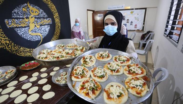 متطوعات بمركز همم يخبزن معجنات لفقراء غزة