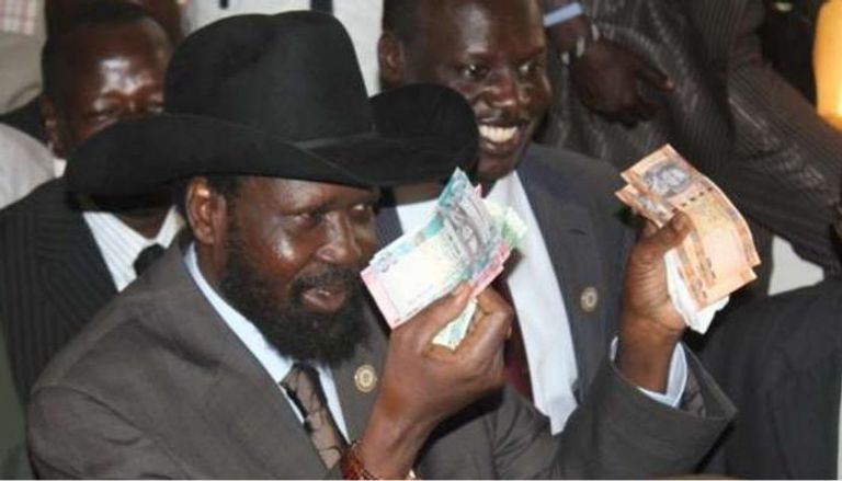 رئيس جنوب السودان يمسك بأوراق نقد.. أرشيفية