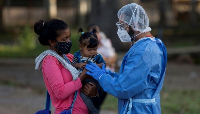 طبيب من المركز الصحي التابع لمنظمة أطباء بلا حدود بفنزويلا يعاين امرأة وطفلها