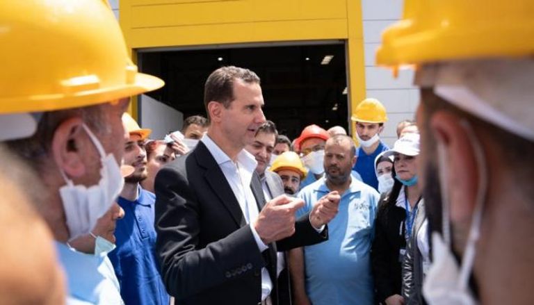 الأسد خلال زيارة أحد المصانع في حمص