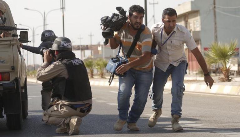 صحفيون عراقيون خلال تغطية اشتباكات في العراق - أرشيفية