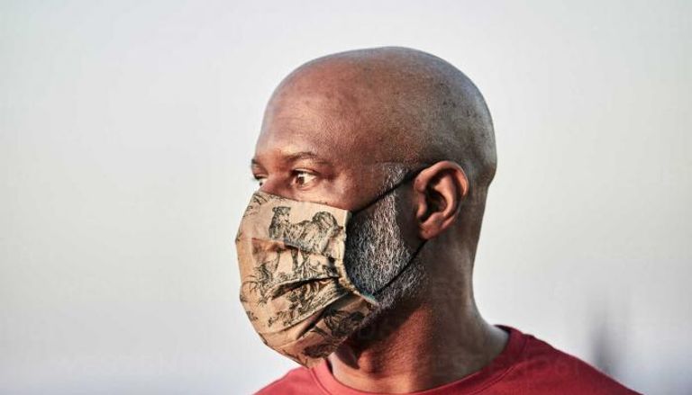 رجل أصلع يرتدي كمامة للوقاية من فيروس كورونا - صورة تعبيرية