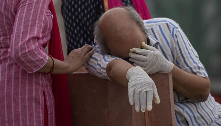 هندي يبكي بعد وفاة أحد أقاربه متأثرا بفيروس كورونا
