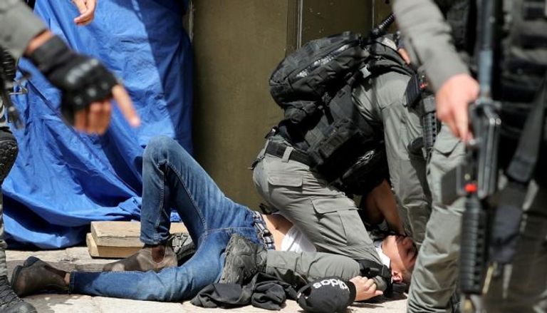 جندي إسرائيلي يجثم على صدر فتى فلسطيني في القدس