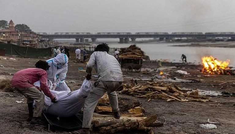 عدد من جثث ضحايا كوفيد يجري حرقها بجوار نهر الجانج