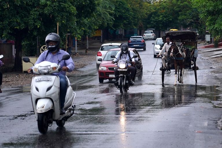 شرطي يساعد سائق نقل عام على عبور شارع غمرته المياه في مومباي
