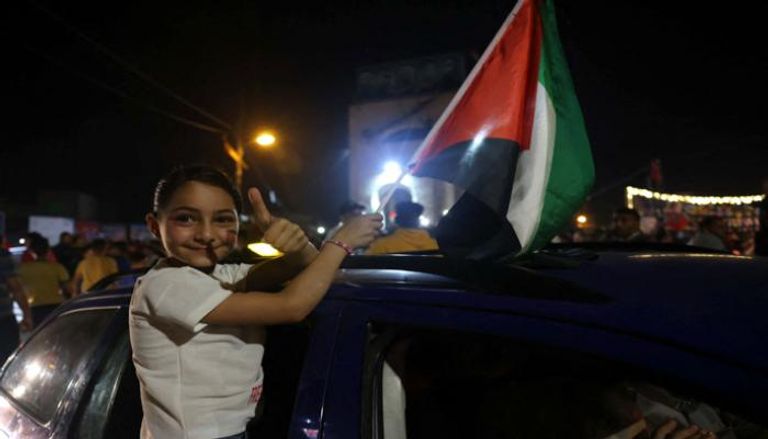 طفلة فلسطينية تحتفل بدخول الهدنة حيز التنفيذ - أ.ف.ب