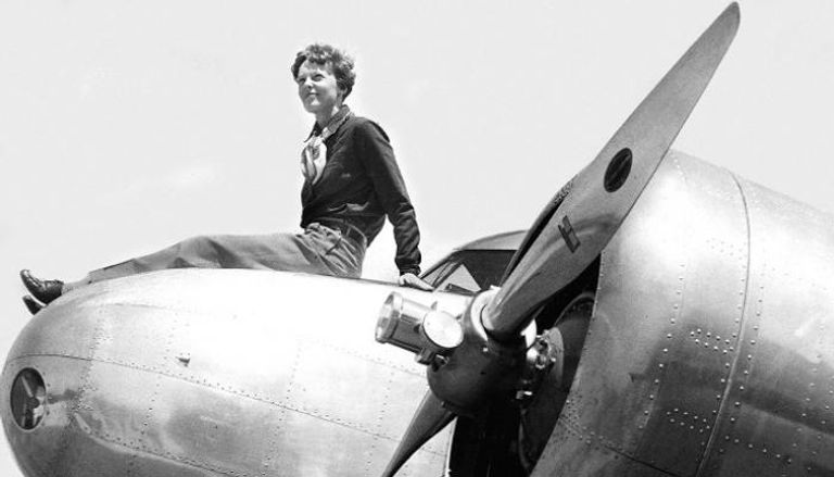 أميليا إيرهارت تجلس فوق مقدمة طائرتها في عام 1936