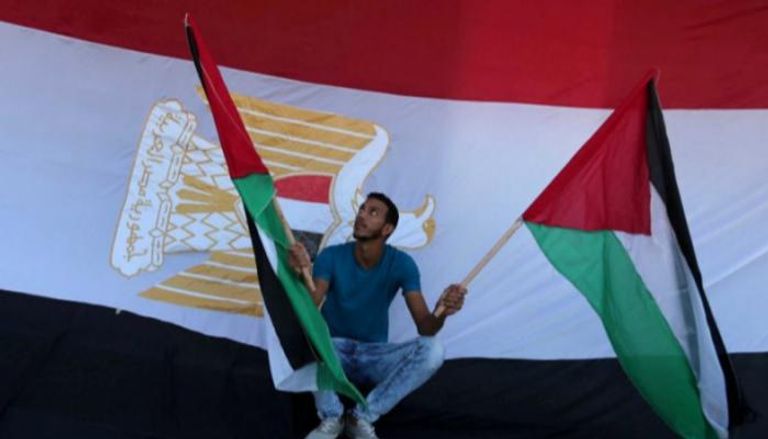 شاب يحمل العلم الفلسطيني وخلفه علم مصر - أرشيفية