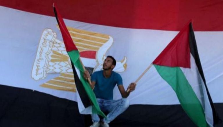  شاب يحمل العلم الفلسطيني وخلفه علم مصر - أرشيفية 
