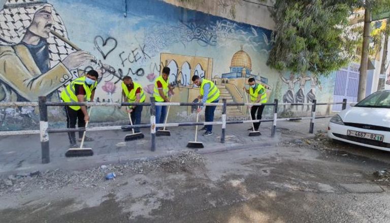 شبان متطوعون ضمن حملة تنظيف شوارع غزة