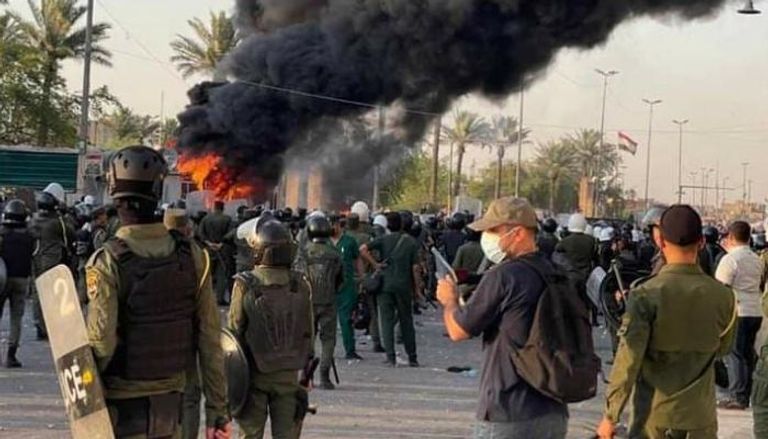 متظاهرون يضرمون النار بكرافانات تابعة لقوات أمنية ببغداد