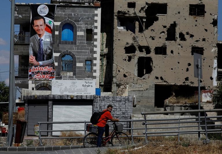 صورة دعائية للأسد على مبنى مدمر