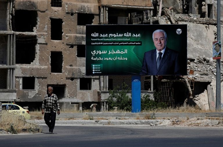 صورة دعائية للأسد على مبنى مدمر