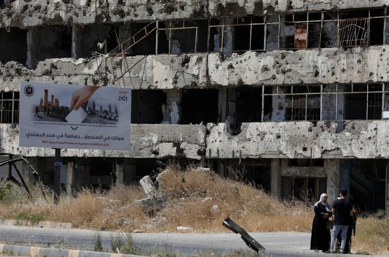 صورة دعائية للأسد على مبنى مدمر