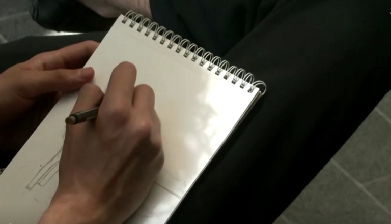 الشاب الأردني أحمد الريماوي يقدم رسمة لأحد الأشخاص