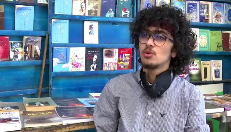 الشاب الأردني أحمد الريماوي يقدم رسمة لأحد الأشخاص