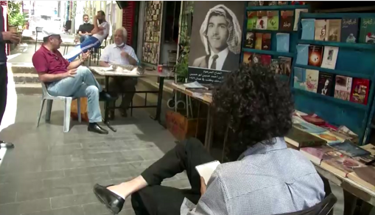 الشاب الأردني أحمد الريماوي يقدم رسمة لأحد الأشخاص