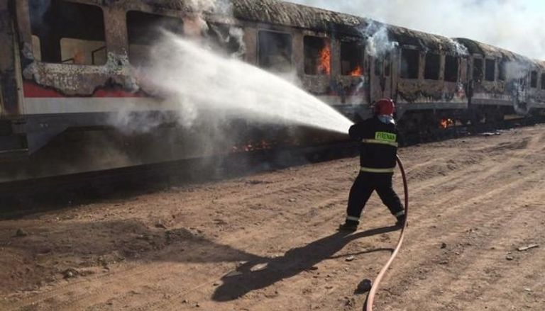 عامل إطفاء  يحاول إخماد حرائق القطار