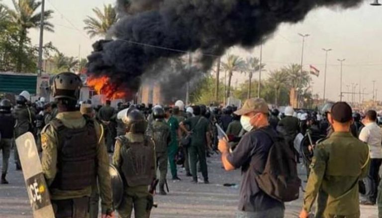 متظاهرون يضرمون النار بكرافانات تابعة لقوات أمنية ببغداد 