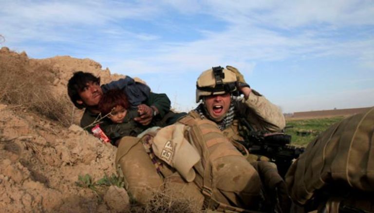 جندي أمريكي يحاول حماية أفغاني وابنه خلال هجوم لطالبان في 2010