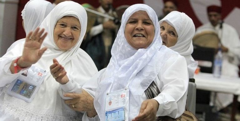 سيدة تقف أمام الكعبة الشريفة