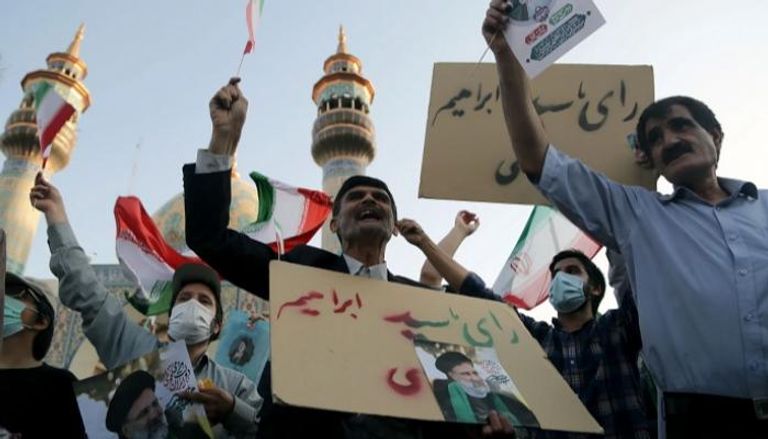 إيرانيون يحملون صور إبراهيم رئيسي - نيويوركر