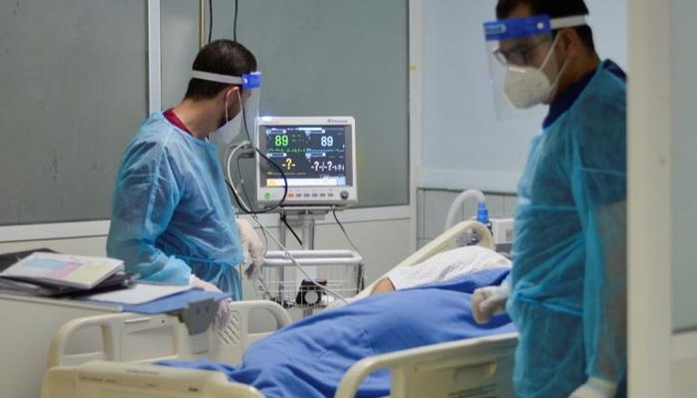 طبيبان يتابعان أحد مصابي فيروس كورونا في مستشفى بالأردن