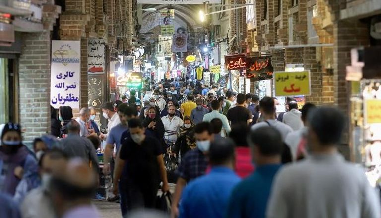 إيرانيون في إحدى المناطق التجارية بطهران- رويترز