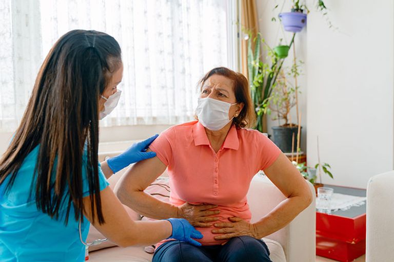 طبيبة تفحص سيدة لديها آلالام نتيجة الدورة الشهرية - تعبيرية سيدة تحصل على لقاح كورونا