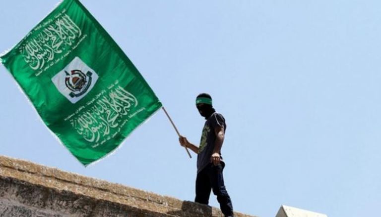 أحد أعضاء حماس يحمل علم الحركة - أرشيفية