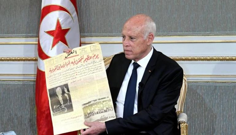 الرئيس التونسي قيس سعيد يحمل عددا من صحيفة العمل